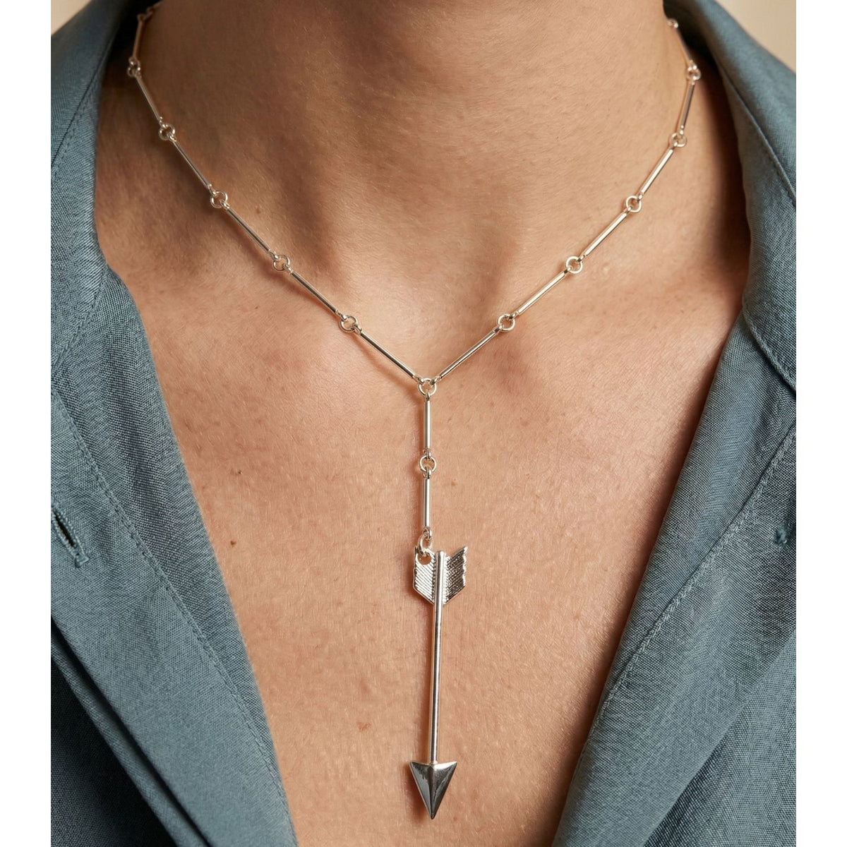 Silver Archer Bar Link Necklace by JAREDJAMIN Jewelry: unisex, silver-plated, arrow-shaped pendant and small circular links with signature brushed texture. Artisanal Craftsmanship Small-batch/West Hollywood, Sustainable Luxury. Draped over blue collar shirt.