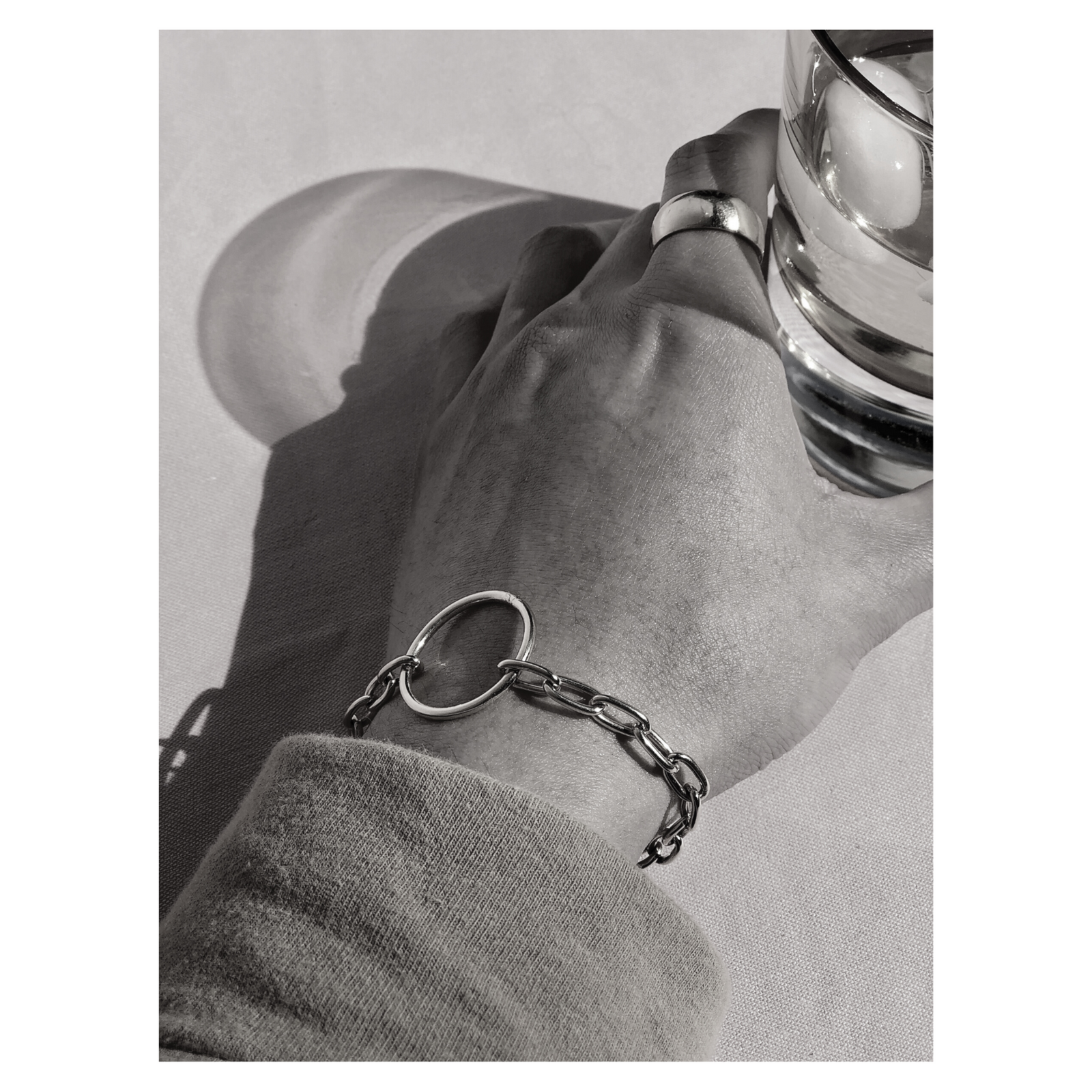 The Silver Chain Reaction Ellipse Bracelet by JAREDJAMIN Jewelry Online features elongated oval links, a central circular ring, lobster clasp closure, and a minimalist rectangular tag for a modern touch. Part of the Chain Reaction Collection.