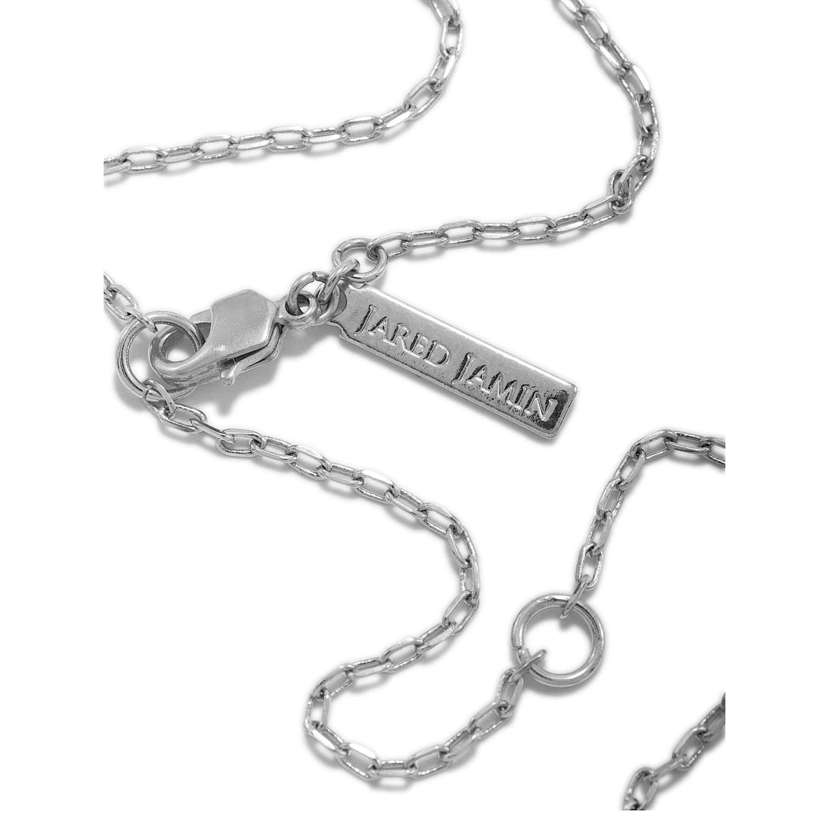 A close-up of the Chandler Adjustable Chain Necklace by JAREDJAMIN Jewelry Online, featuring a silver oval link design, lobster clasp, and a rectangular "JARED JAMIN" tag, loosely displayed on a white background.