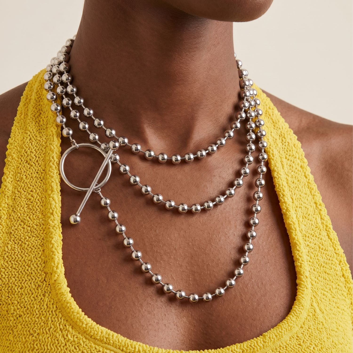 Los plata Constellation Orbita collar de JAREDJAMIN Joyería Online features reflective plata spheres y a toggle clasp con a circular aro y bar, laid flat en un gentle loop sobre un fondo blanco.