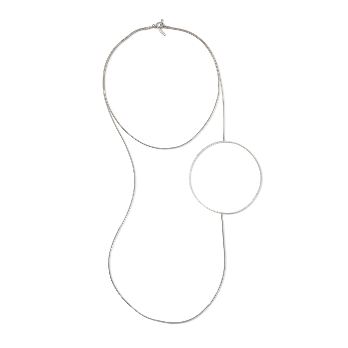 The Silver Halo Necklace by JAREDJAMIN Jewelry Online features a sleek silver-tone chain with a bold circular pendant, creating a gentle curve and minimalist look against a white background.