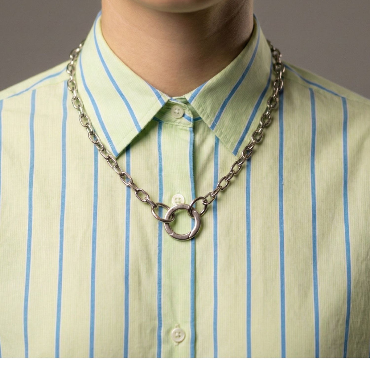 A subtle wash of pale green and tailored blue-white stripes sets the stage for our Silver Medium Circular Clicker Clasp necklace—hand-assembled in our West Hollywood studio, crafted in eco-conscious small batches. Style Note: punctuates knitwear or sharp shirting.