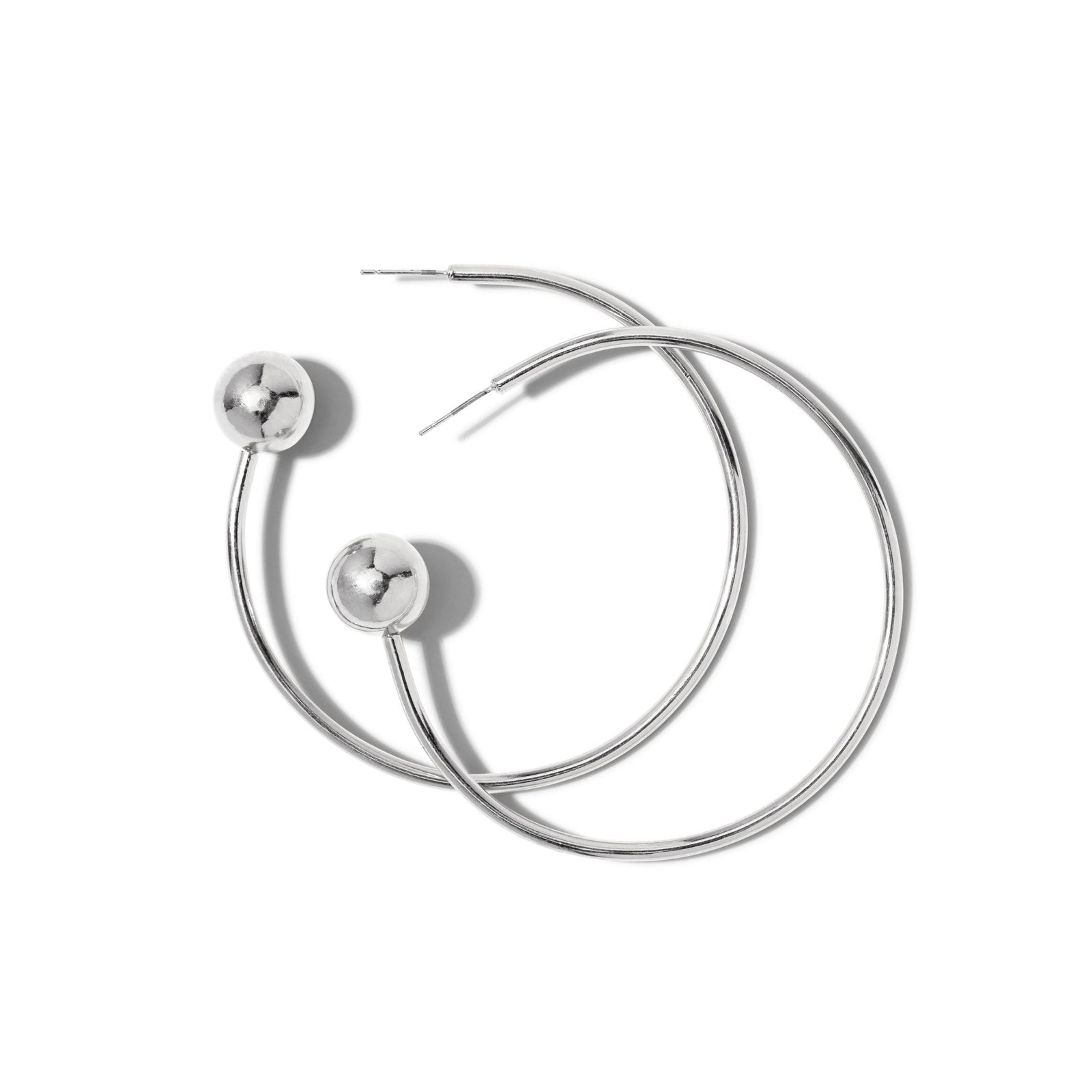 The Silver Orbita Comet Earrings by JAREDJAMIN Jewelry Online feature two large, silver rhodium hoops with a smooth, shiny bead near the post. Their 3" drop offers a modern, minimalist style, shown overlapping on a white background.