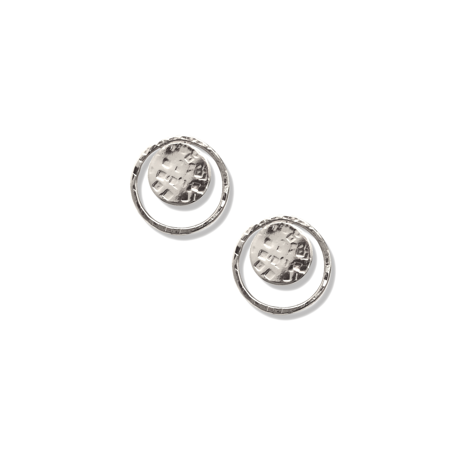 Two Silver Peacock Eye Clip On Earrings by JAREDJAMIN Jewelry Online are displayed on a white background, each featuring a round textured disk with a hammered grid pattern and an irregular hoop for a handcrafted look.