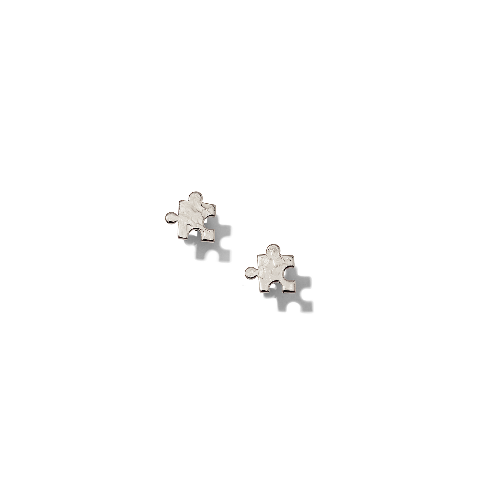 Two Puzzle Piece Textured Stud Post Earrings by JAREDJAMIN Jewelry Online are shown on a white background—one upright to display the front, the other flat to reveal the post and back of this elegant design.