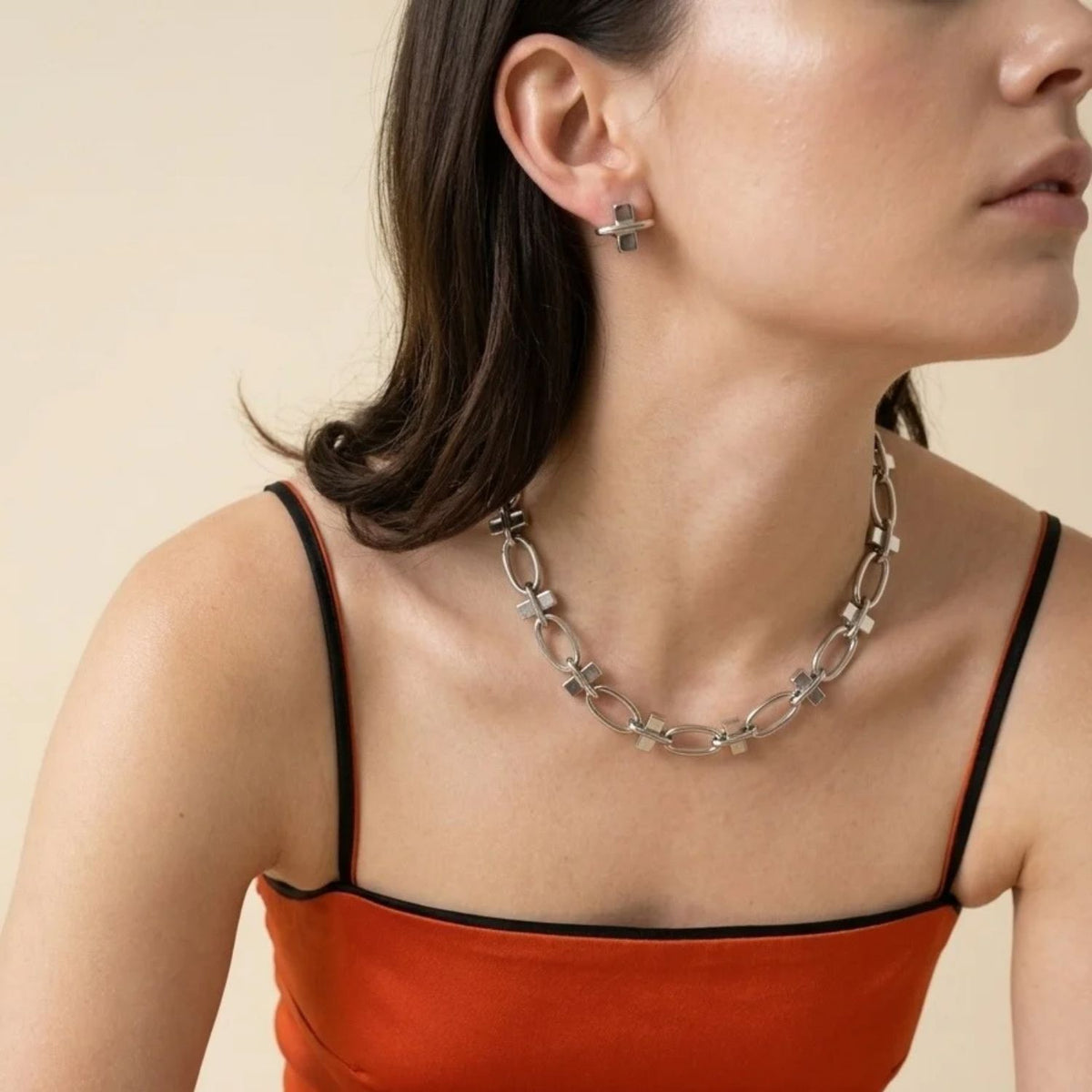 Silver Reign Collier Necklace, model wearing a silver link necklace of polished oval links and squared block connectors.