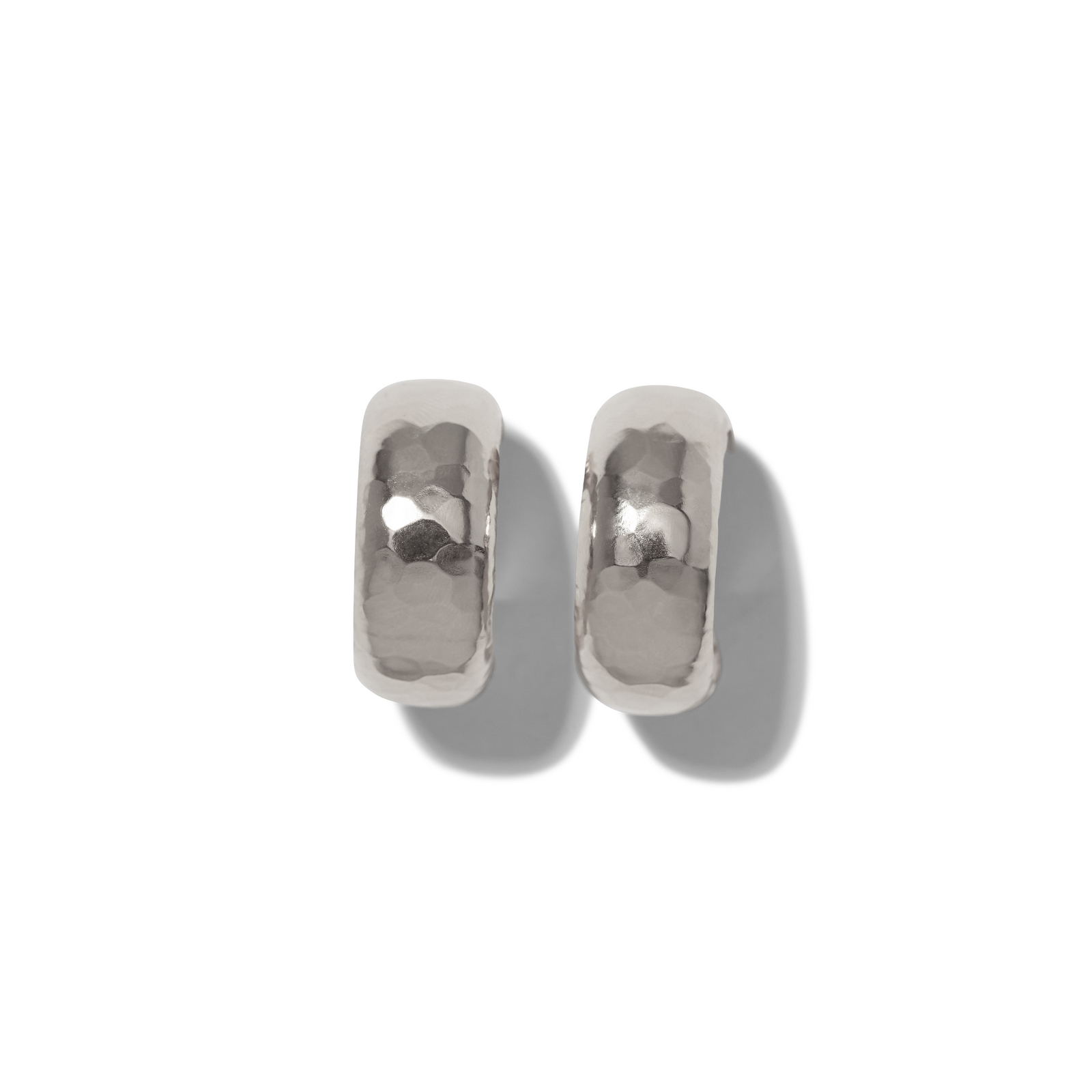 The Silver Rush Hoop Earrings by JAREDJAMIN Jewelry Online are chunky, silver plate hammered-metal hoops shown on a white background. Soft gray shadows highlight their rounded, reflective surfaces and textured finish.