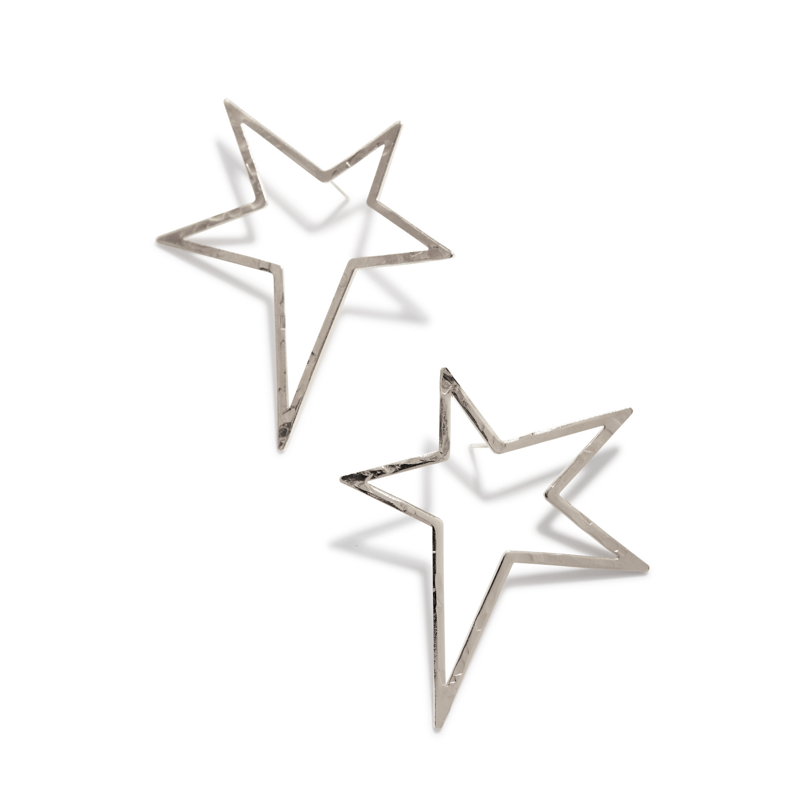 The JAREDJAMIN Jewelry Online Silver Shooting Star Dust Post Earrings feature two metallic, open-outline star shapes with sharp angles and a modern, minimalist design displayed on a white background. Shadows enhance their three-dimensional look.