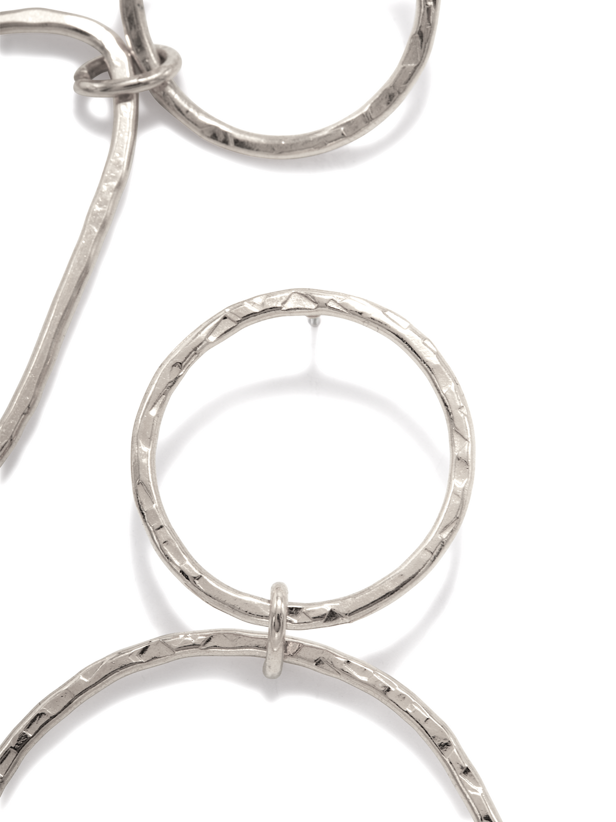 Close-up of textured silver earrings with interlocking circular links featuring a hammered design. The White Rhodium finish beautifully highlights the vertical arrangement of three linked circles on a white background. Product: Silver Textured Tear Post Earrings by JAREDJAMIN Jewelry Online.