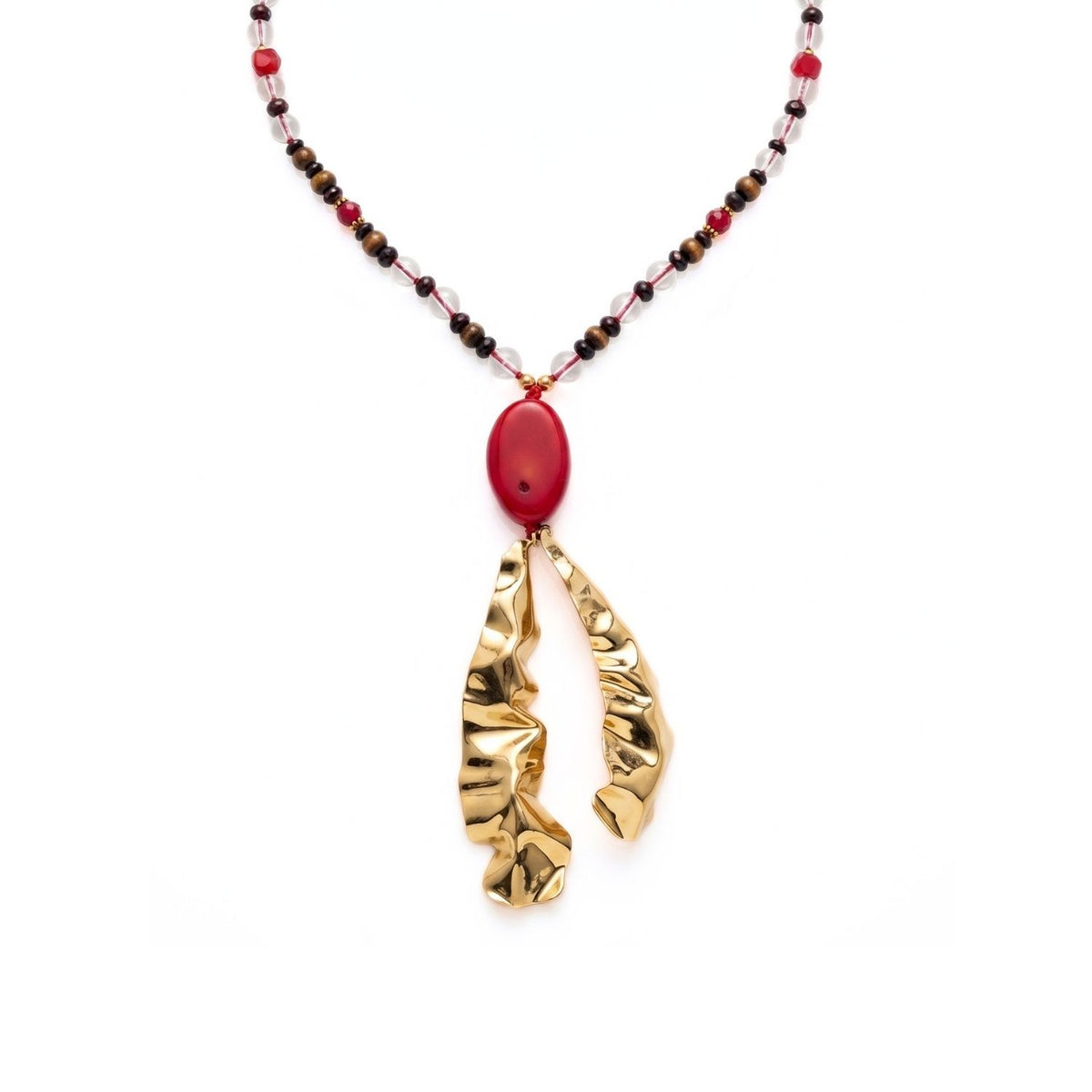 Close-up macro studio detail focusing on the massive 5-inch pendant drop of the Solange necklace, showcasing the large polished red coral stone and the two uniquely hand-formed, 18k gold-plated molten brass accents.
