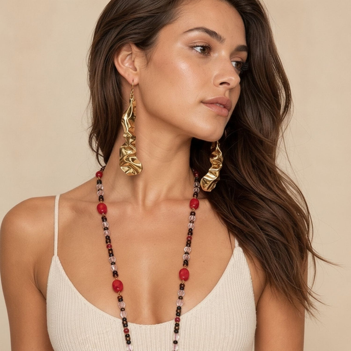 Close-up profile portrait of a female model demonstrating the fluid, molten liquid-gold aesthetic of the 4-inch Solange Hand-Formed Gold Drop Earrings and their elegant French hook hardware.