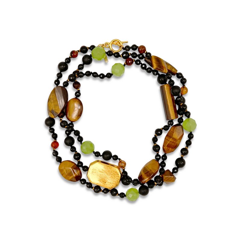 The Sorrento Gemstone Knotted Necklace by JAREDJAMIN Jewelry Online features multiple strands of polished tiger’s eye, faceted green quartz, onyx beads, and gold accents, all secured with a gold toggle clasp.
