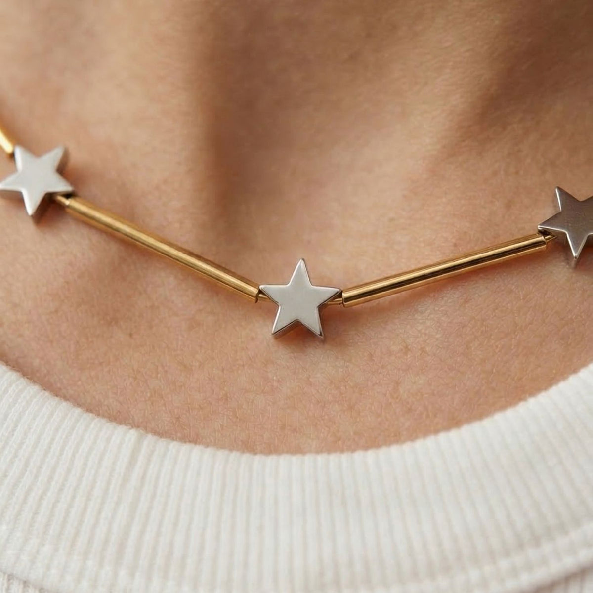 The Starlight Plated Hematite Necklace showcases gold bars and silver star charms with a luminous finish. Material: plated hematite. Origin: JAREDJAMIN Essential—Artisanal, Sustainable, Signature Texture from West Hollywood.