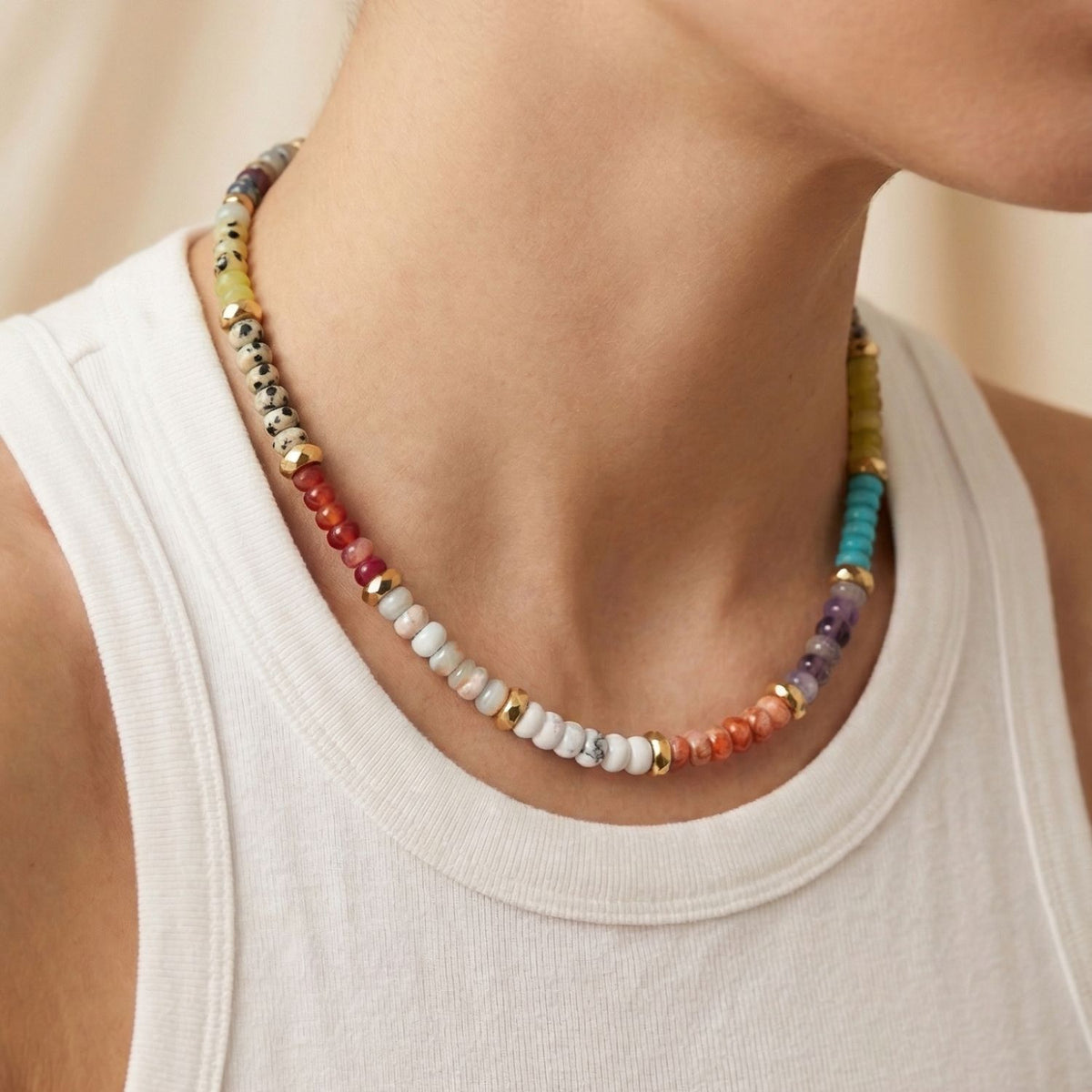Lower face, neck, and shoulders in frame—a sleeveless white ribbed shirt sets the canvas for the Taylor Beaded Necklace Dalmatian. Hand-assembled in our West Hollywood studio with small-batch care and eco-mindfulness. Style Note: punctuates tailored or off-duty looks alike.