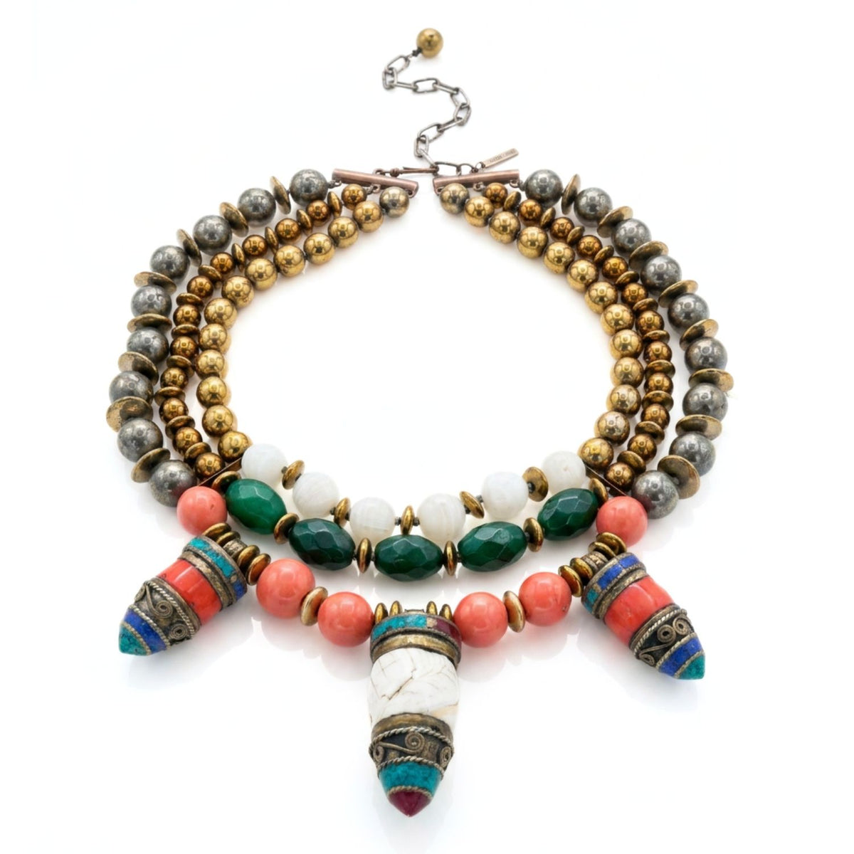 Studio product shot of the Tibetan Tide multi-strand collar necklace displayed flat in a full loop against a white background, showing the gold hematite strands, hand-knotted construction, and hook-and-extension clasp with brand tag.