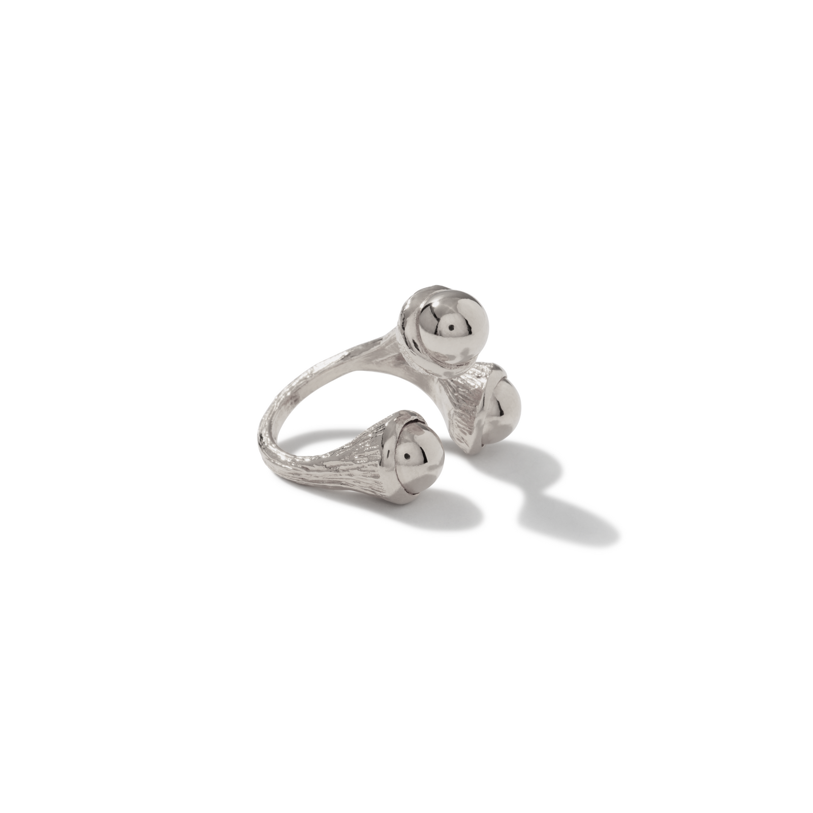 The Silver Trinity Acorn Ring by JAREDJAMIN Jewelry Online features three textured, flared silver bands ending in polished spheres. Displayed on a white background with a soft right shadow, this modern, sculptural ring offers an adjustable fit.