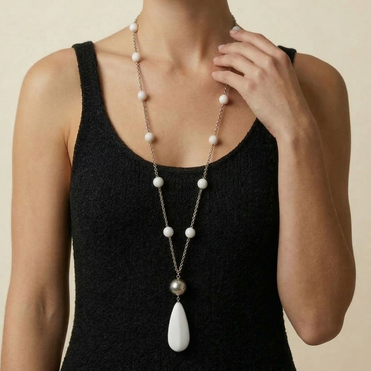 Model wearing the 37-inch Jared Jamin Bianca Necklace, showcasing the dramatic 3.75-inch white stone teardrop pendant and the long, brushed silver-plated segmented chain.