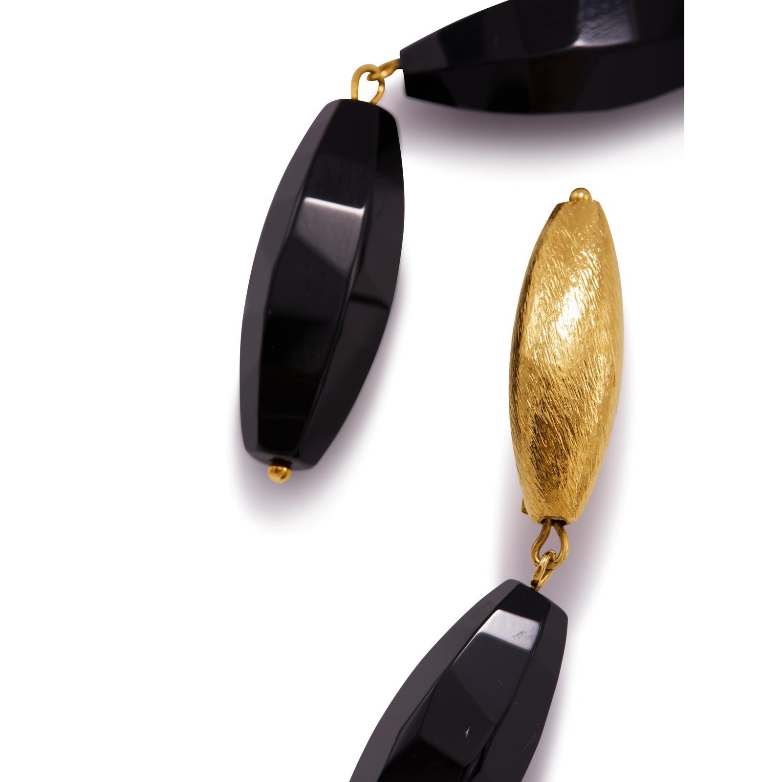 The Zeppelin Gold Isla Onyx Clip On Earrings by JAREDJAMIN Jewelry Online feature brushed 18K gold textured oval posts with two elongated, faceted onyx beads linked vertically, shown against a white background.