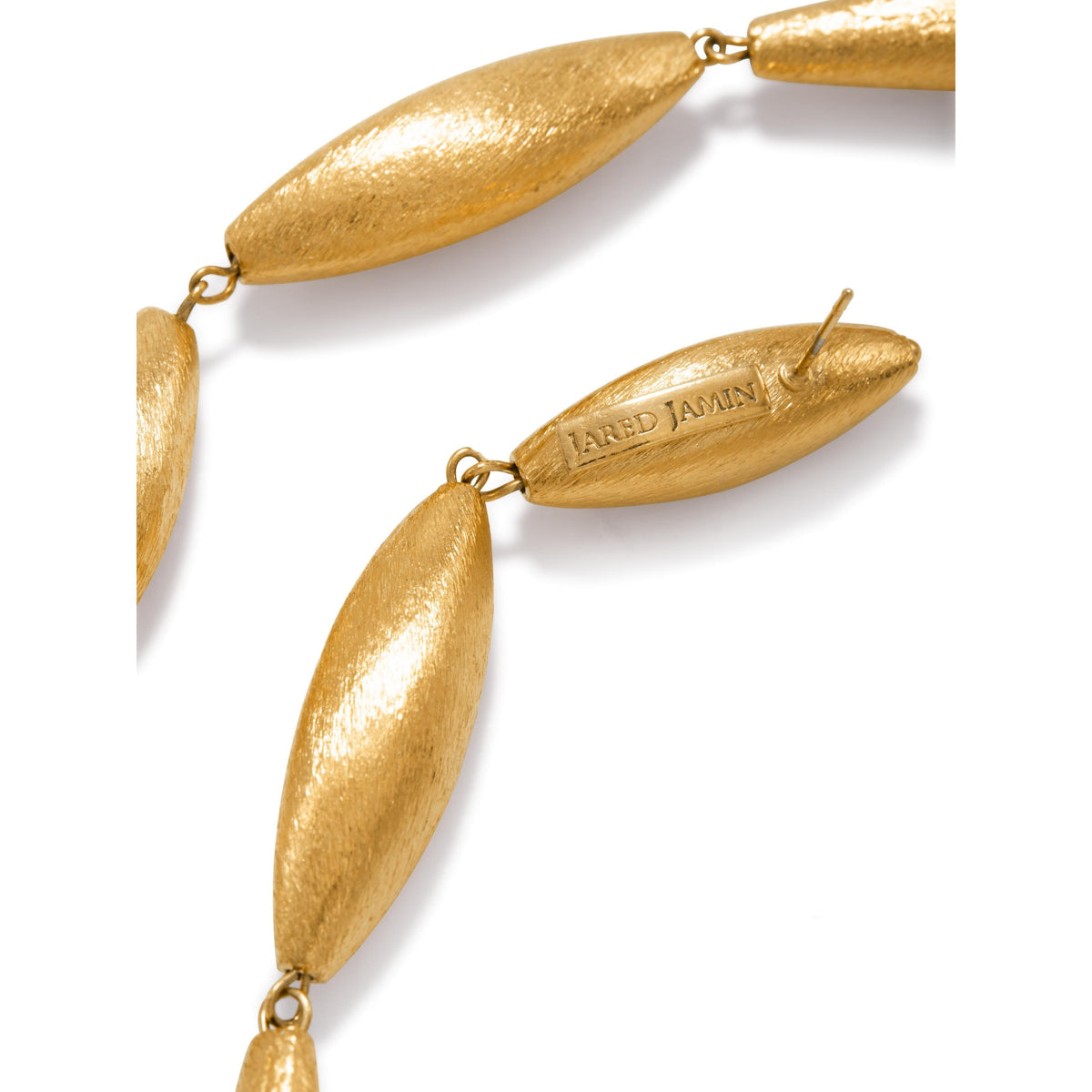 gros plan of or Zeppelin Isla Three pendante boucles d'oreilles par JAREDJAMIN bijoux. Les boucles d'oreilles présentent elongated oval links avec a brushed or finish, an engraved clasp, et a design inspiré par zeppelins, showcasing modern elegance.
