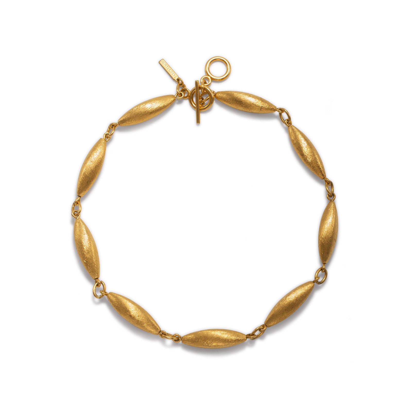 The Zeppelin Phoebe Gold Necklace by JAREDJAMIN Jewelry Online features eight elongated, textured oval links and small round rings, finished in matte gold with a toggle clasp and rectangular tag for vintage flair.