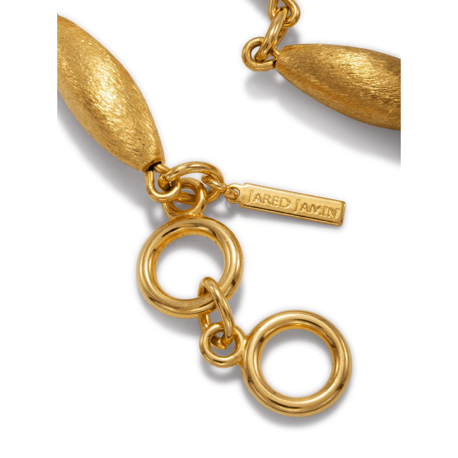 The Zeppelin Phoebe Gold Bracelet by JAREDJAMIN Jewelry Online features four 18K goldplated, zeppelin-shaped beads linked by round connectors, a toggle clasp with a circular ring and bar, and a small rectangular tag near the clasp. Displayed on a white background.