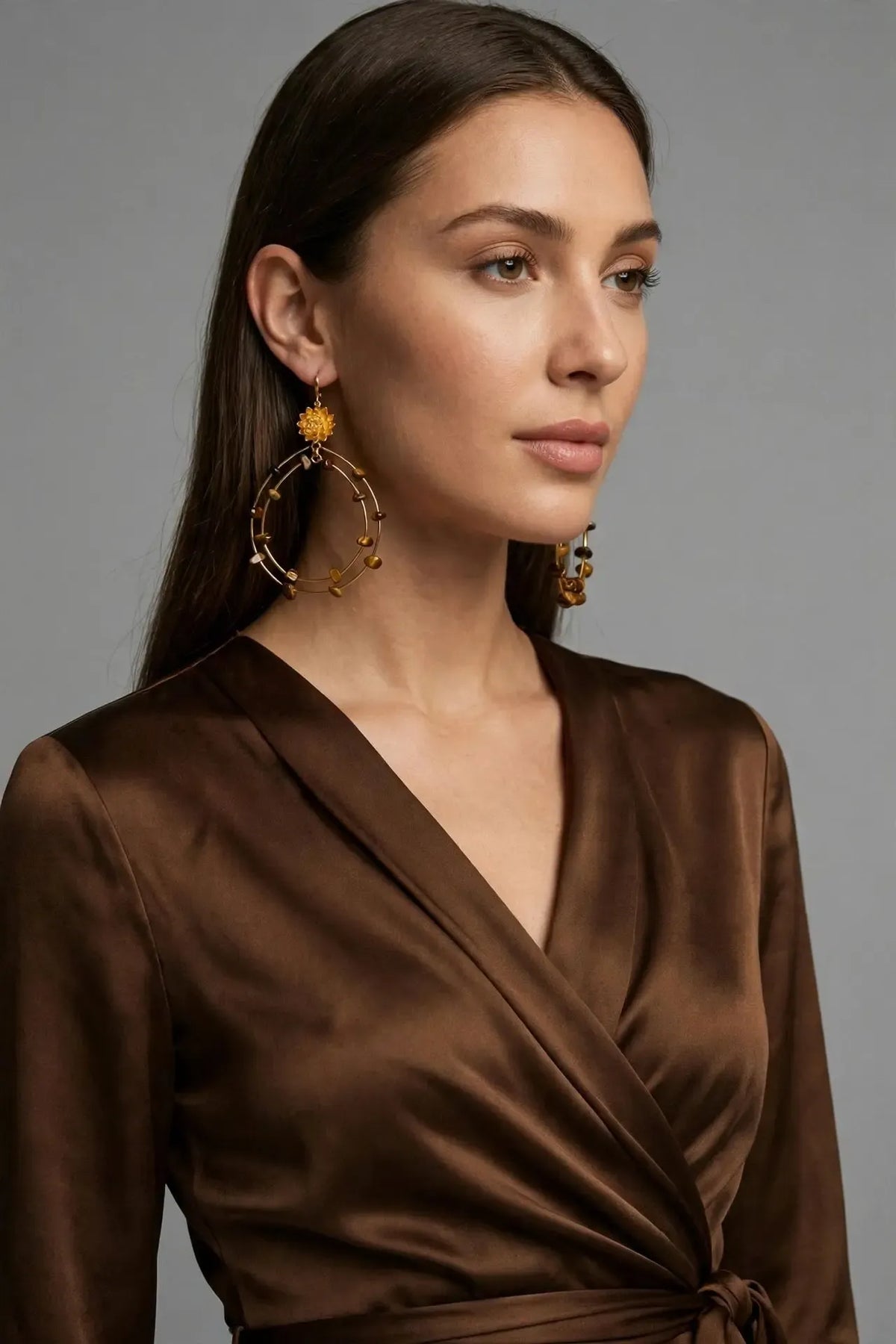 Model wearing the Lotus Dream Tiger's Eye Chandelier Earrings in 18K Gold Plated with a bronze silk dress