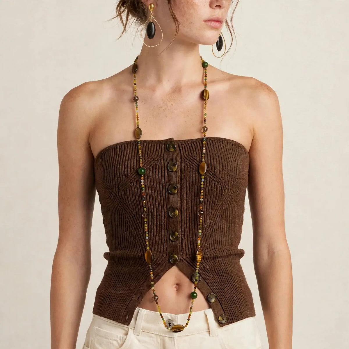 Model wearing the 48-inch Terra tiger's eye long beaded necklace with smoky quartz and green gemstone accents, paired with Petra jasper hoop earrings