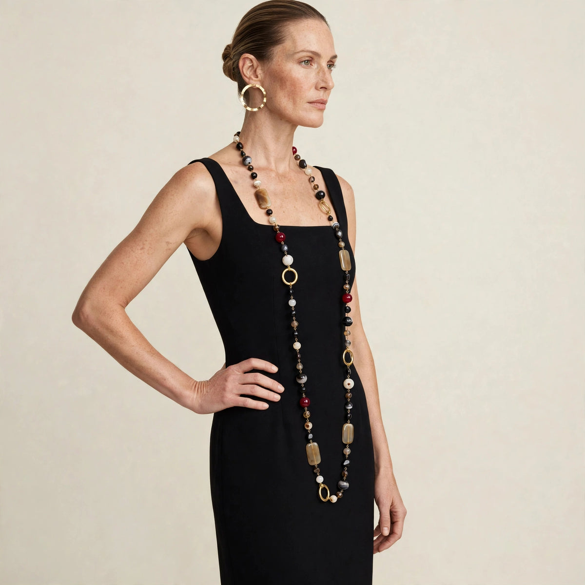 Model wearing the Via Condotti long beaded necklace, hand on hip pose