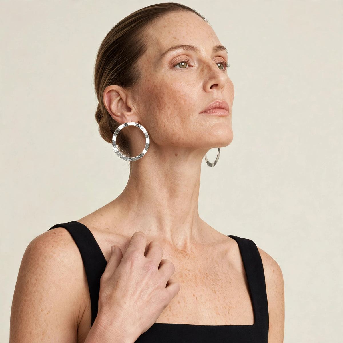 Close-up of silver duet post earrings on model