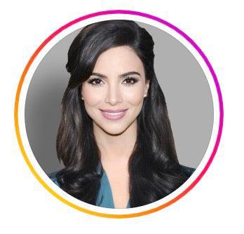 Smiling woman with long, dark hair styled in loose waves, wearing a teal blouse. The profile picture has a circular Instagram-style border with a gradient of orange, pink, and purple. The background is a simple gray.