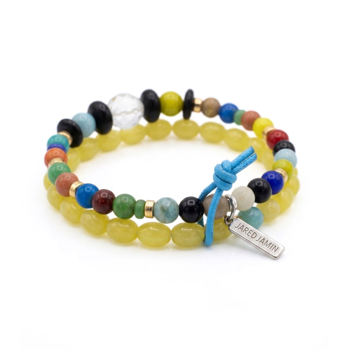 Angled studio shot showcasing the circular layout of the Elio glass bead bracelets, highlighting the signature JAREDJAMIN metal brand tag and the clean alignment of the gold-plated rondelles.