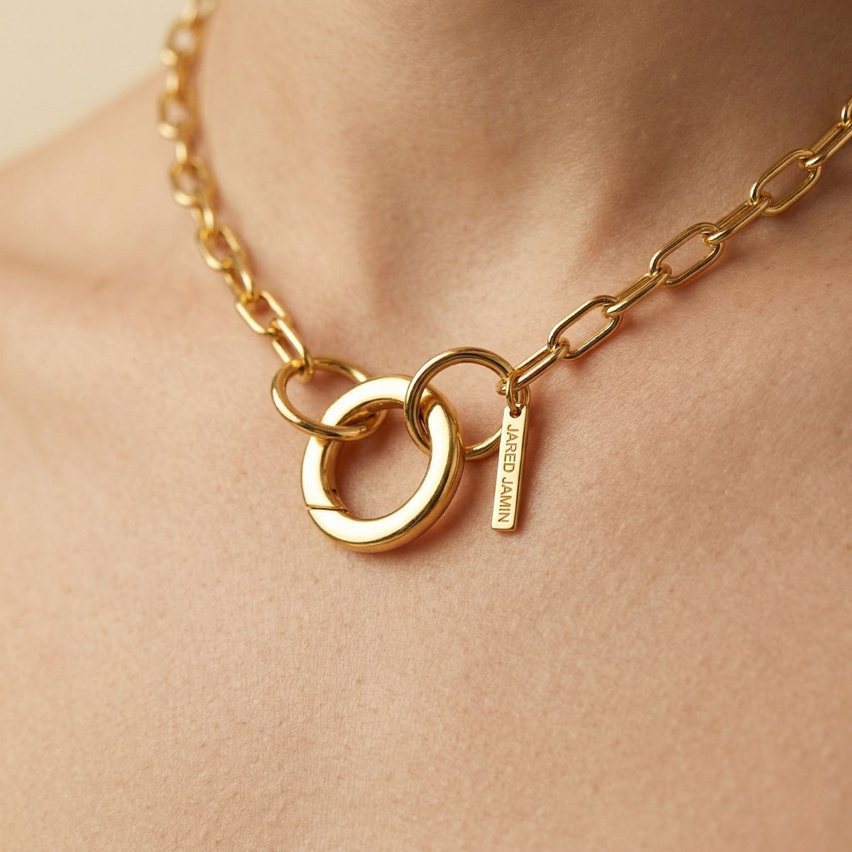 A close-up of the Gold Chain Reaction Connector Necklace—hand-assembled in our West Hollywood studio. Sculpted 18k gold-plated links are accented by a circular pendant and “JANE WIN” tag. Small-batch, eco-conscious. Style Note: punctuates denim as effortlessly as silk.