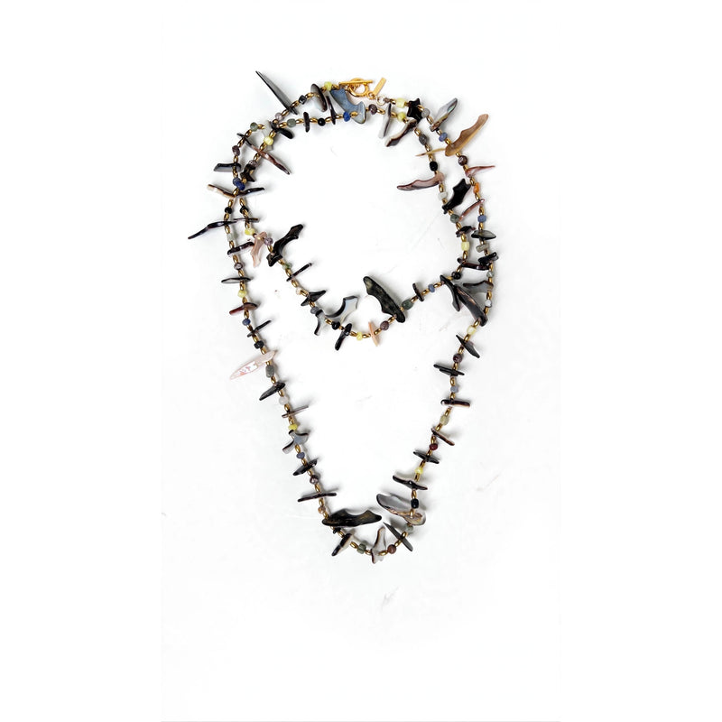 Caracola shell shard necklace styled doubled on a white background