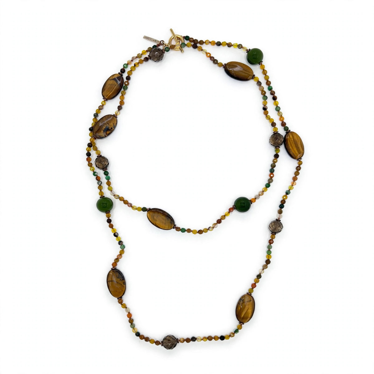 The long beaded necklace worn doubled, hanging as two concentric loops on a white background: tiger's eye ovals, smoky quartz rounds, and green gemstone rounds distributed across both loops among tiny amber, honey, olive, and brown faceted agate beads; gold-tone toggle clasp and JAREDJAMIN tag at the top.