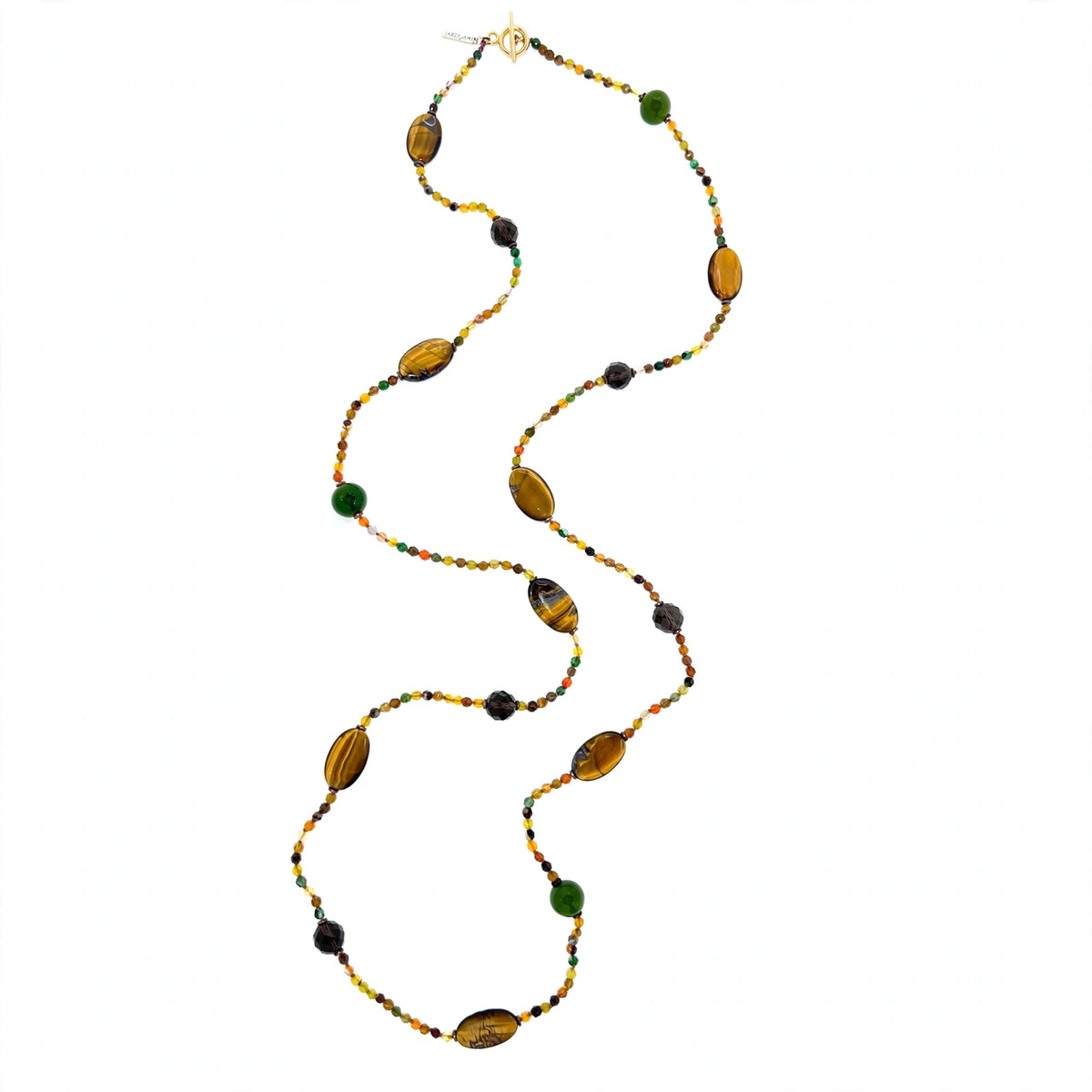 A long beaded necklace arranged in a vertical S-curve on a white background: oval tiger's eye cabochons with golden-brown bands, dark faceted smoky quartz rounds, and green gemstone rounds spaced along the strand, each separated by runs of tiny faceted agate beads in amber, honey, olive, and brown; a gold-tone toggle clasp and small JAREDJAMIN tag at the top.