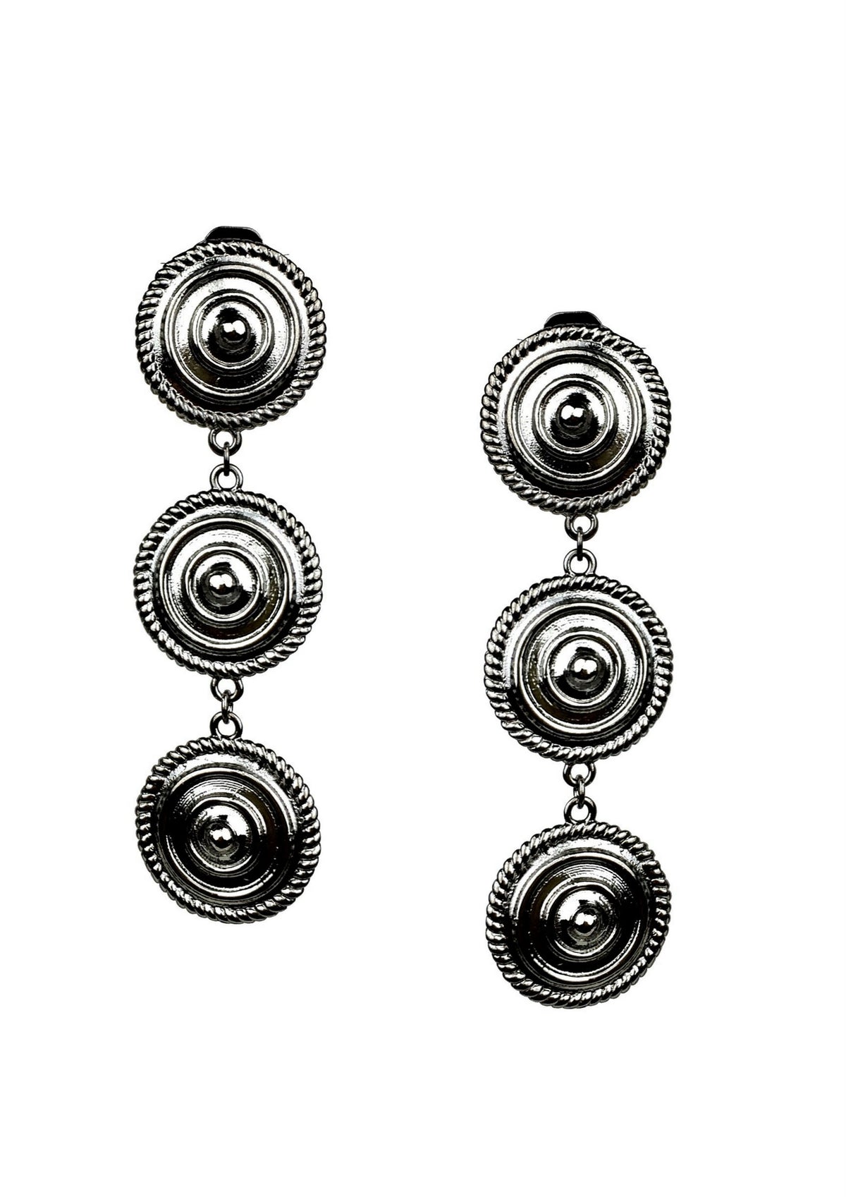 The Minerva Black Clip-on Earrings by JAREDJAMIN Jewelry are bold silver-tone pieces featuring two connected round concentric ridged discs bordered by beaded rope, showcasing a striking, vintage-inspired design.